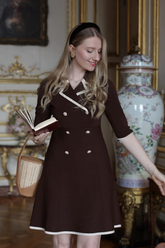 a lady in a black fitted dress with white trim